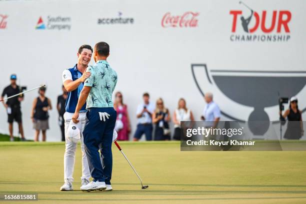 Viktor Hovland of Norway smiles as he greets Xander Schauffele on the 1t8h hole green after clinching a five stroke victory in the final round of the...