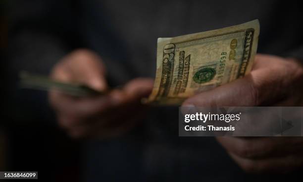 close-up of man's passing a twenty dollar bill - mugger stock pictures, royalty-free photos & images