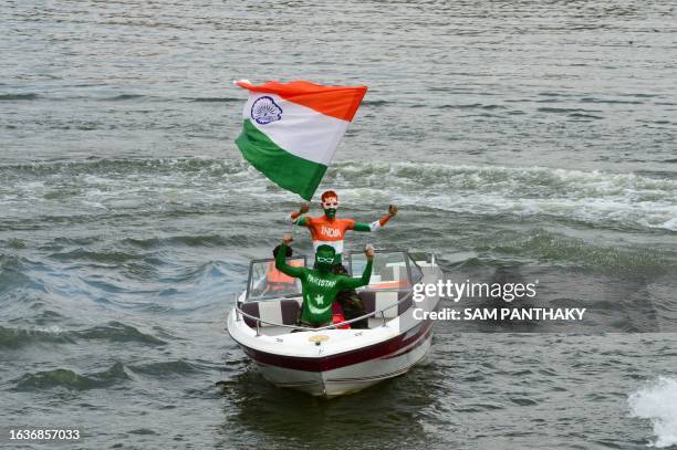 Fans with their bodies painted as national flags of India and Pakistan ride a boat as they wave India's national flag in Ahmedabad on September 1 on...