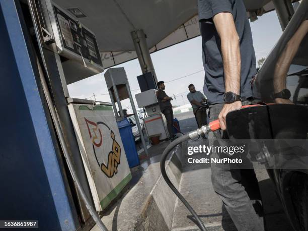 An Iranian man pumps fuel into his vehicle at a petrol station in downtown Tehran, August 31, 2023.