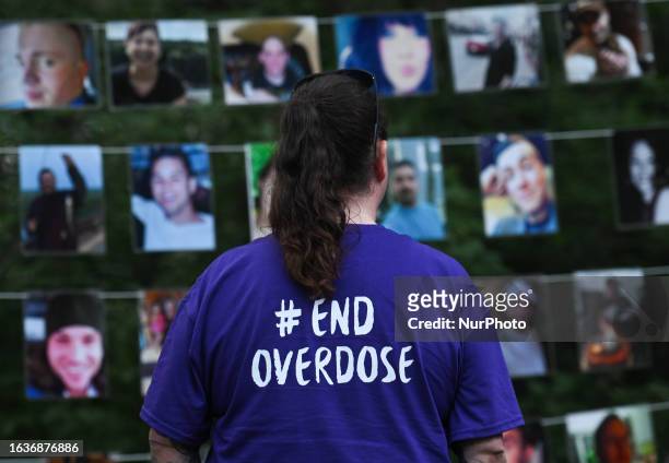 August 31, 2023: A woman looks at photos of those lost to drug overdoses as many Edmontonians gathered at Victoria Park this evening to mark the...