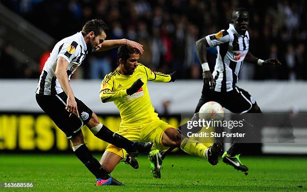 Newcastle player Yohan Cabaye gets his shot off despite the attentions of Mehdi Carcela-Gonzalez during the UEFA Europa League Round of 16 second leg...