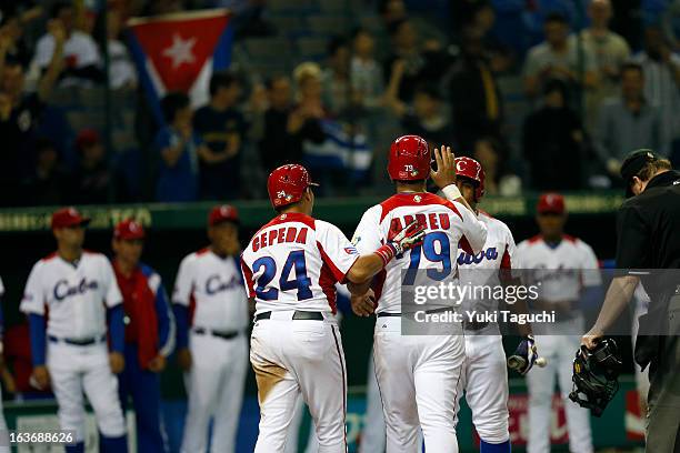 Jose Abreu of Team Cuba is greeted by Frederich Cepeda of Team Cuba at home plate after hitting a two run home run in the bottom of the sixth inning...