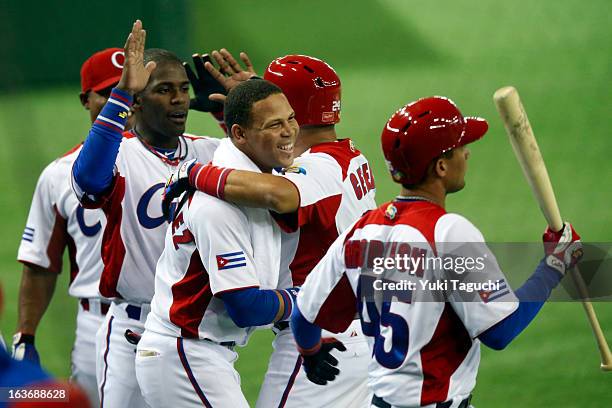 Frederich Cepeda of Team Cuba is greeted by teammates after scoring a run in the bottom of the fourth inning during Pool 1, Game 3 between the...