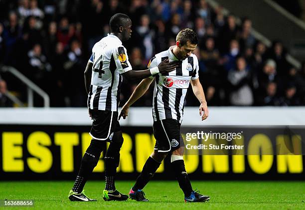 Newcastle player Cheick Tiote consoles captain Yohan Cabaye after he was forced off due to injury during the UEFA Europa League Round of 16 second...