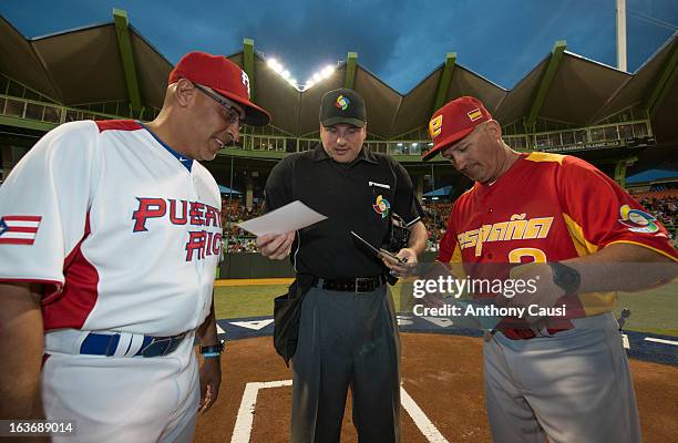 Edwin Rodriguez manager of Team Puerto Rico and Mauro Mazzotti manager of Team Spain exchange line-up cards with home plate umpire Dan Bellino before...