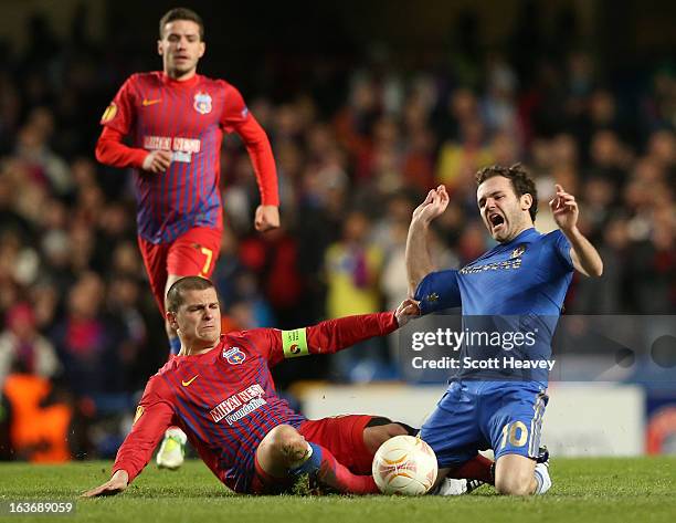 Alexandru Bourceanu of FC Steaua Bucuresti pulls on the shirt of Juan Mata of Chelsea during the UEFA Europa League Round of 16 second leg match...