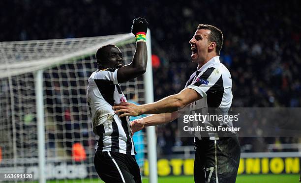 Newcastle players Papiss Cisse and Steven Taylor celebrate the winning goal during the UEFA Europa League Round of 16 second leg match between...