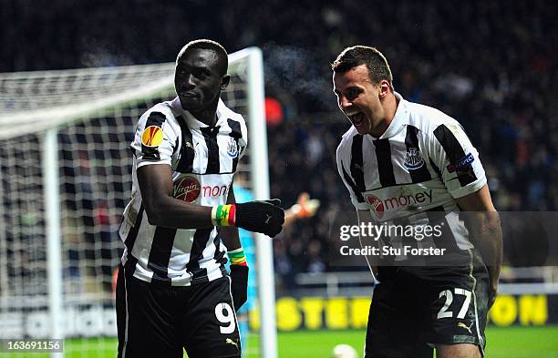 Newcastle players Papiss Cisse and Steven Taylor celebrate the winning goal during the UEFA Europa League Round of 16 second leg match between...