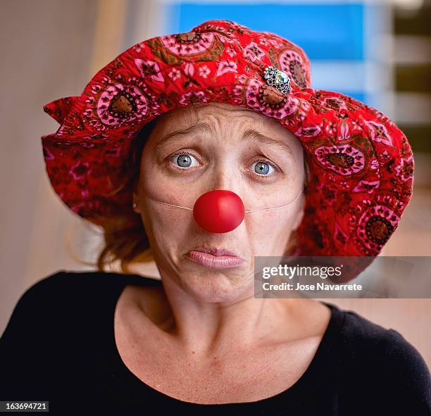 female clown with sad facial expression - clownsneus stockfoto's en -beelden