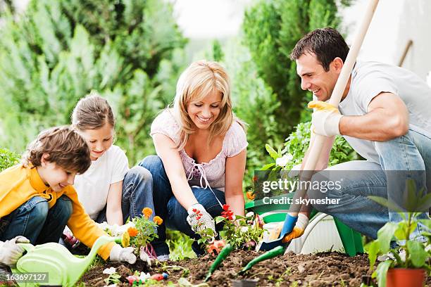 vista frontale di una famiglia di giardinaggio insieme - family planting tree foto e immagini stock