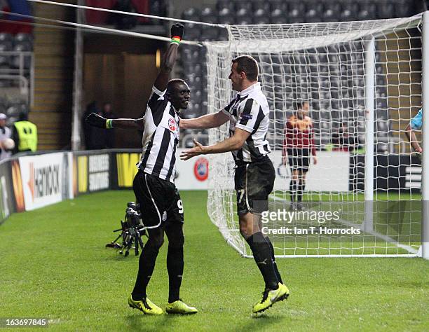 Papis Cisse of Newcastle United celebrates with Steven Taylor after scoring the only goal during the UEFA Europa League Round of 16 second leg match...