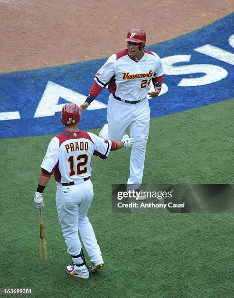 Miguel Cabrera is greeted by teammate Martin Prado of Team Venezuela after scoring a run in the bottom of the sixth inning during Pool C, Game 5...