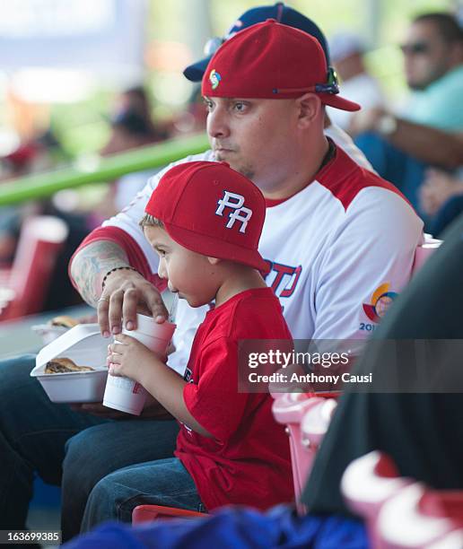 Father and son are seen watching the game from the stands during Pool C, Game 5 between Spain and Venezuela in the first round of the 2013 World...