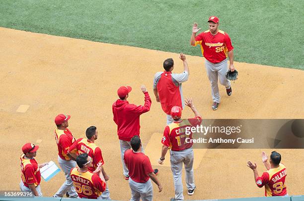 Ivan Granados of Team Spain is greeted by teammates as he walks to the dugout during Pool C, Game 5 against Venezuela in the first round of the 2013...
