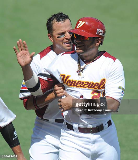 Alex Romero of Team Venezuela is greeted in the dugout after scoring a run in the bottom of the fourth inning Pool C, Game 5 against Spain in the...