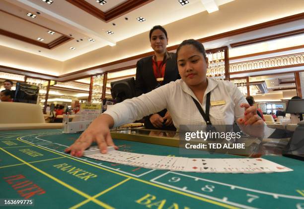 Employees of Solaire Manila Resorts and casino check gaming cards during media day inside the casino in Manila on March 14 ahead of its opening on...