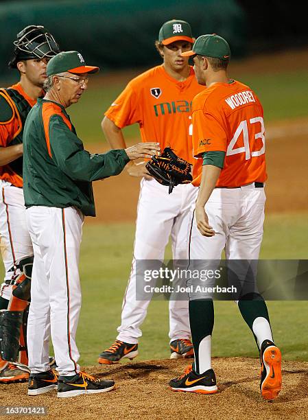 Head coach Jim Morris hands the ball to Thomas Woodrey of the Miami Hurricanes as he is brought in to pitch against the Illinois State Redbirds on...