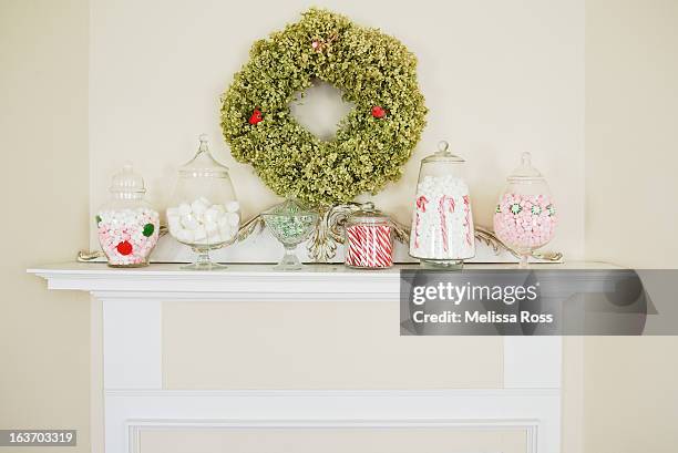 mantel decorated with candy filled apothecary jars - mantelpiece stock pictures, royalty-free photos & images