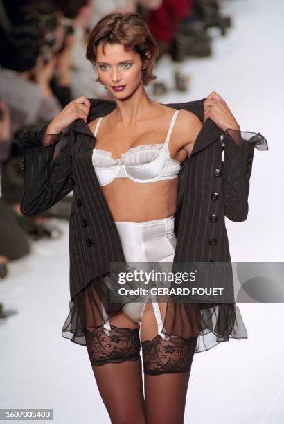 British model Heather Stewart-Whyte presents a mousseline trimmed suit jacket over a frilled white bra, and lace stockings during the Chantal Thomass...