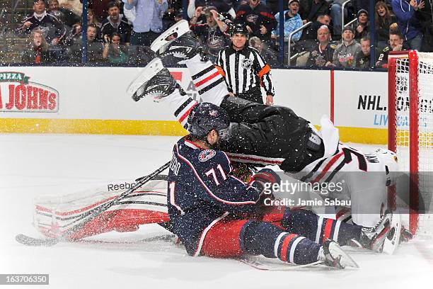 Andrew Shaw of the Chicago Blackhawks falls over goaltender Corey Crawford of the Chicago Blackhawks and Nick Foligno of the Columbus Blue Jackets...