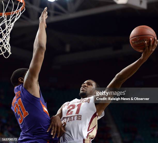 Florida State's Michael Snaer shoots over the defense of Clemson's Devin Booker during the first half in the men's ACC basketball tournament at...