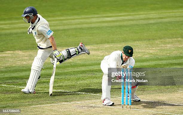Tim Paine of Tasmania attempts to run out Chris Rogers of Victoria during day two of the Sheffield Shield match between the Tasmania Tigers and the...