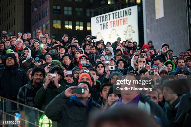 Spectators gather and use their smartphones to document the release of the Samsung Electronics Co. Galaxy S4 smartphone in Times Square in New York,...