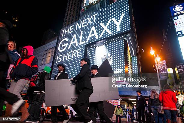 Samsung Electronics Co. Signage is displayed on billboards as pedestrians walk by during the release of the Samsung Electronics Co. Galaxy S4...