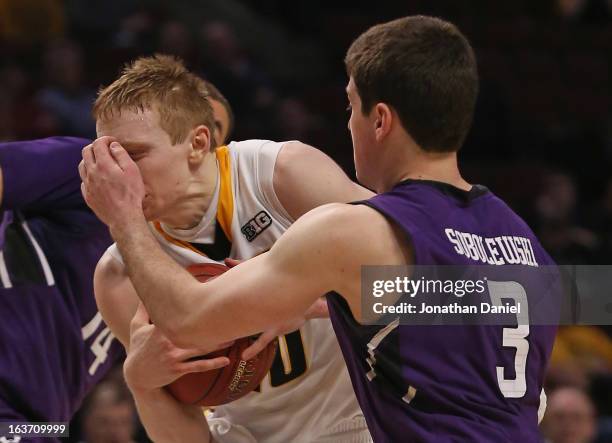 Dave Sobolewski of the Northwestern Wildcats fouls Mike Gesell of the Iowa Hawkeyes during a first round game of the Big Ten Basketball Tournament at...