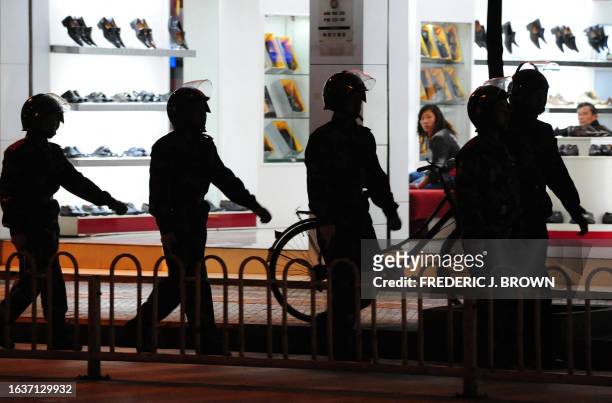 By Robert Saiget Shopkeepers watch as Chinese paramilitary forces march on patrol through the streets of Lijiang on March 24, 2008 in southwest...