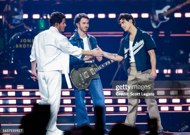 Nick Jonas, Kevin Jonas and Joe Jonas perform onstage during Jonas Brothers “Five Albums, One Night” Tour at Little Caesars Arena on August 24, 2023...