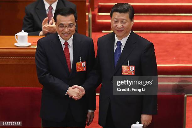 Chinese President Xi Jinping shakes hands with newly-elected Premier Li Keqiang as former Chinese Premier Wen Jiabao looks on during the fifth...