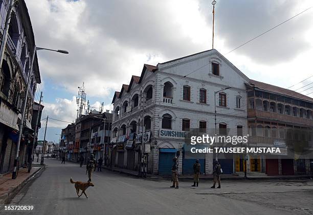 Indian Paramilitary soldiers stand guard during the second day of curfew, imposed on the Kashmiri summer capital in Srinagar on March 15, 2013....