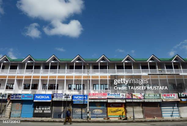 An Indian policeman patrols during the second day of curfew, imposed on the Kashmiri summer capital in Srinagar on March 15, 2013....