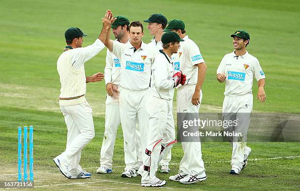 Peter Handscomb of Tasmania celebrates with team mates after bowling Evan Gulbis during day two of the Sheffield Shield match between the Tasmania...