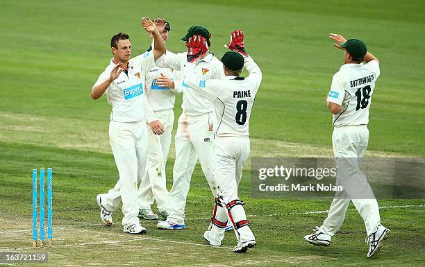 Peter Handscomb of Tasmania celebrates with team mates after bowling Evan Gulbis during day two of the Sheffield Shield match between the Tasmania...