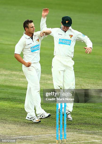 Jordan Silk and Evan Gulbis of Tasmania celebrate the wicket of Peter Handscomb of Victoria during day two of the Sheffield Shield match between the...