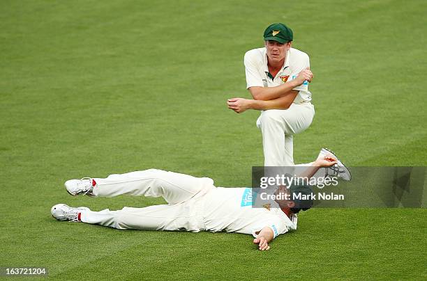 Ben Hilfenhaus and James Faulkner of Tasmania stretch during a break in play on day two of the Sheffield Shield match between the Tasmania Tigers and...