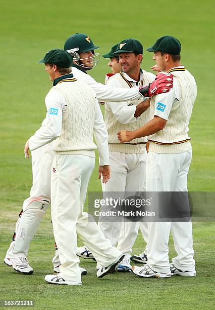 Tim Paine and Ricky Ponting of Tasmania congratulate Evan Gulbis after taking a catch during day two of the Sheffield Shield match between the...