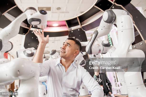 Journalist stands inside a multi-robotics-system by German startup Hydrabyte at the 2023 IFA consumer electronics and home appliances trade fair on...