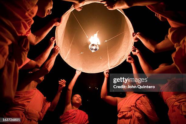 Buddhist monks launch a sky lantern or khom loy -as its known in Thailand- during the Yee Peng Festival in Chiang Mai. By releasing the lanterns to...