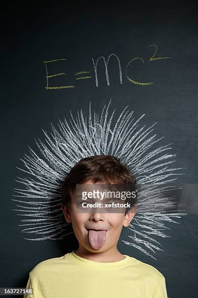 boy imitating einstein photo in front of chalkboard - einstein stock pictures, royalty-free photos & images