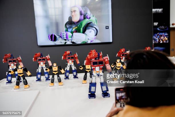 Woman filming robots made by Robosen during theat the 2023 IFA consumer electronics and home appliances trade fair on September 1, 2023 in Berlin,...