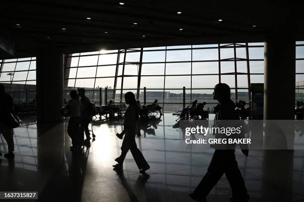 Passengers walk to boarding gates at the domestic terminal of Beijing Capital Airport in Beijing on September 1, 2023.