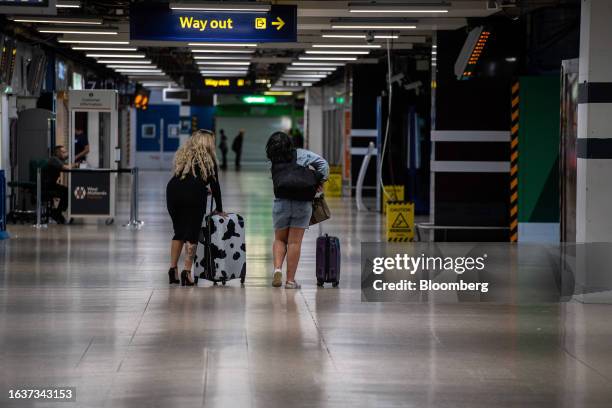 Passengers wheel luggage along a near-empty concourse during train drivers strike action at Euston railway station in London, UK, on Friday, Sept. 1,...