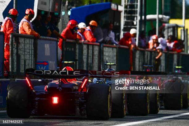 Drivers including Red Bull Racing's Mexican driver Sergio Perez queue to leave the pit lane following a red flag during the second practice session,...