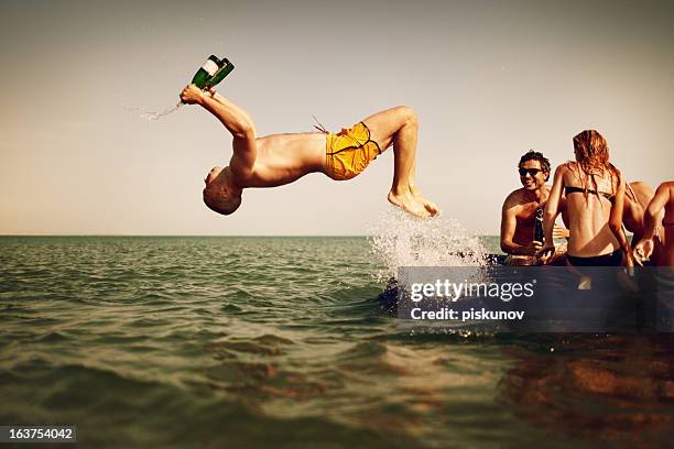 young people enjoying beach party - young men drinking beer stock pictures, royalty-free photos & images