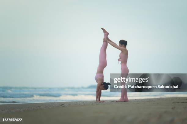 yoga beach - acrobatiek stockfoto's en -beelden
