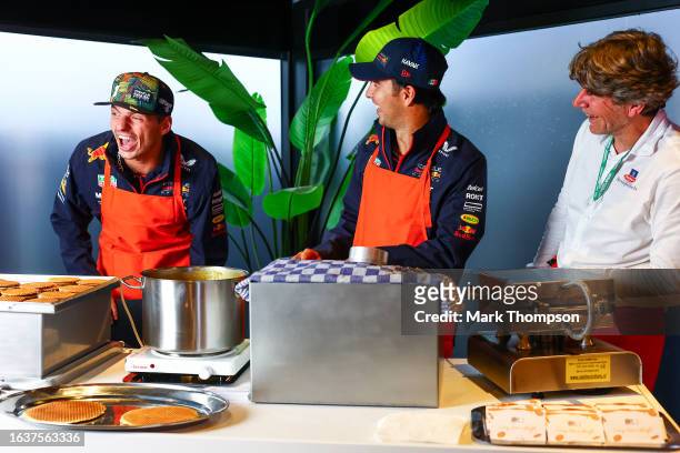 Sergio Perez of Mexico and Oracle Red Bull Racing and Max Verstappen of the Netherlands and Oracle Red Bull Racing cook stroopwafels in the Paddock...